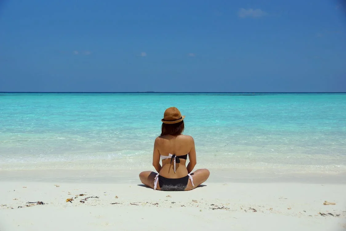 Mulher fazendo yoga e meditação na Praia